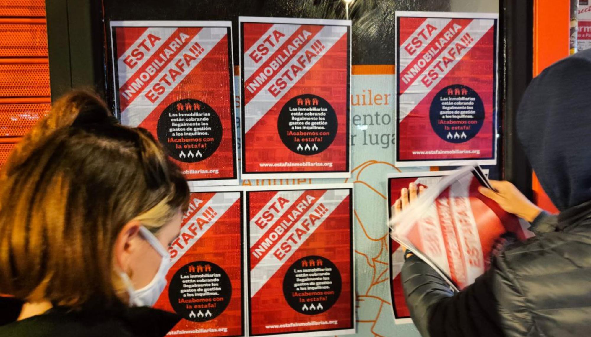 Activistas por el derecho a la vivienda empapelan una oficina de Alquiler Seguro para denunciar que se está saltando la Ley de Vivienda.